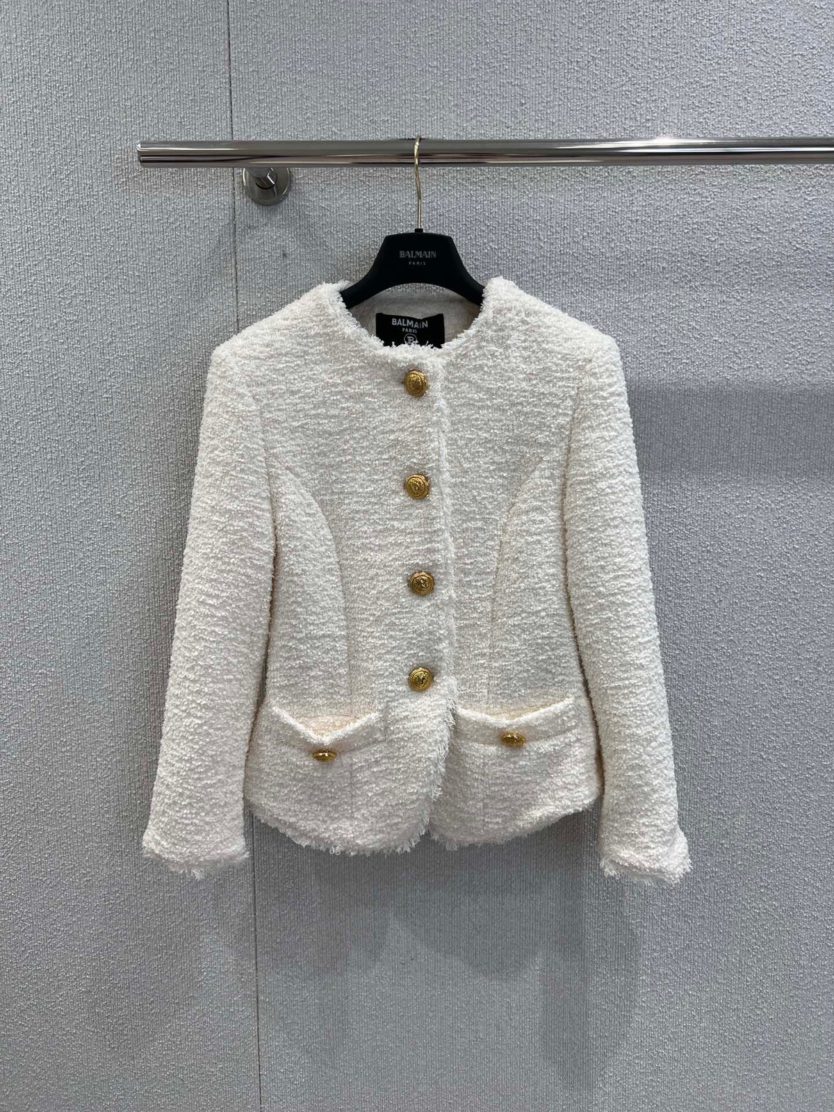 Gold-buttoned, slim-fit cropped tweed jacket.