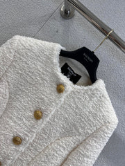 Gold-buttoned, slim-fit cropped tweed jacket.