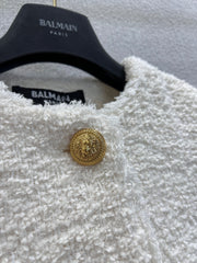 Gold-buttoned, slim-fit cropped tweed jacket.